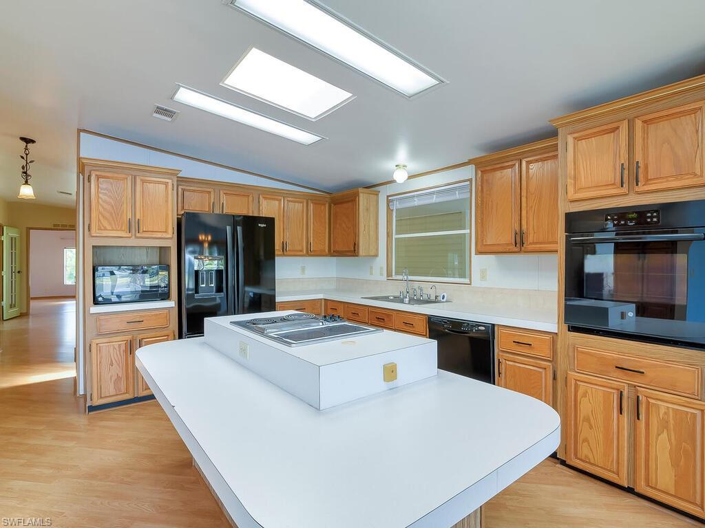 269 Riverwood Road Naples, FL 34114 - Photo 9 of 32 a kitchen with granite countertop a sink a counter top space and stainless steel appliances