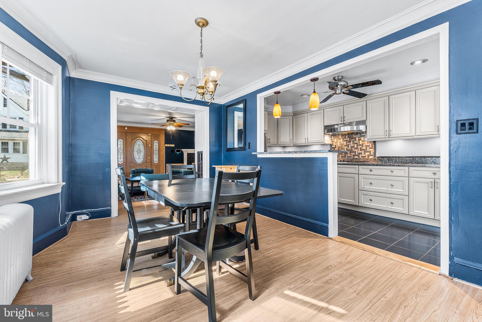 295 Braddock Avenue Lansdowne, PA 19050 - Photo 11 of 36 a dining room with wooden floor a chandelier a wooden table and chairs