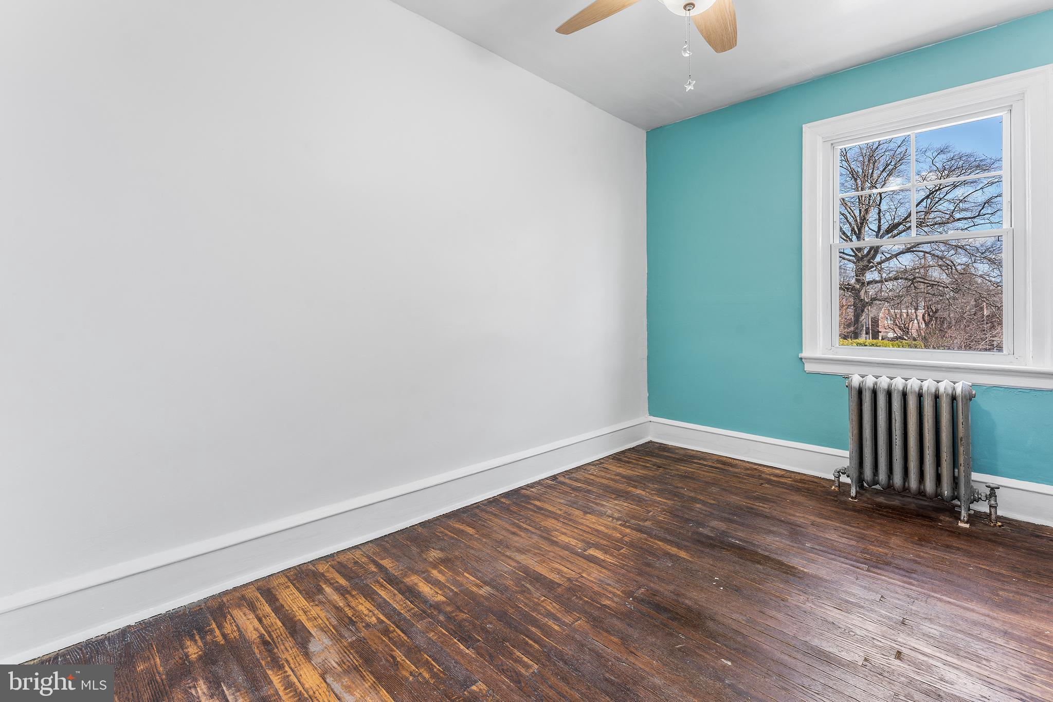 295 Braddock Avenue Lansdowne, PA 19050 - Photo 21 of 36 an empty room with wooden floor a chandelier fan and windows