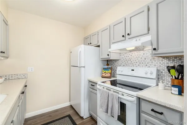 a kitchen with stainless steel appliances a refrigerator a sink a stove and white cabinets