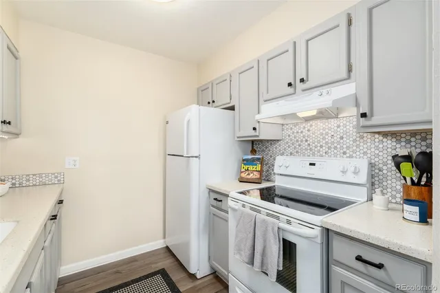 a kitchen with stainless steel appliances a refrigerator a sink a stove and white cabinets