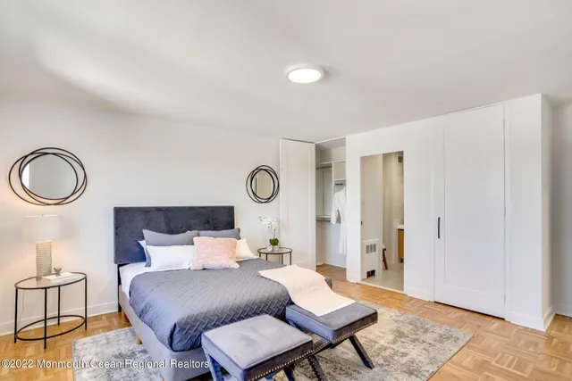 a bedroom with a bed a large window and chair