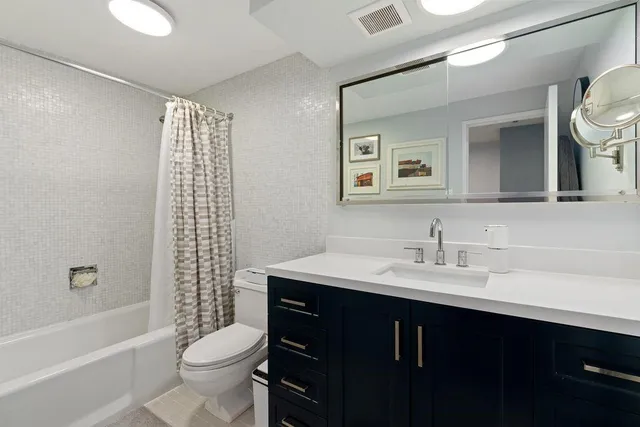 a bathroom with a sink toilet a mirror and shower