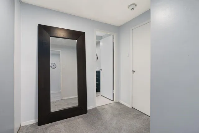 a view of an empty room with closet and wooden floor