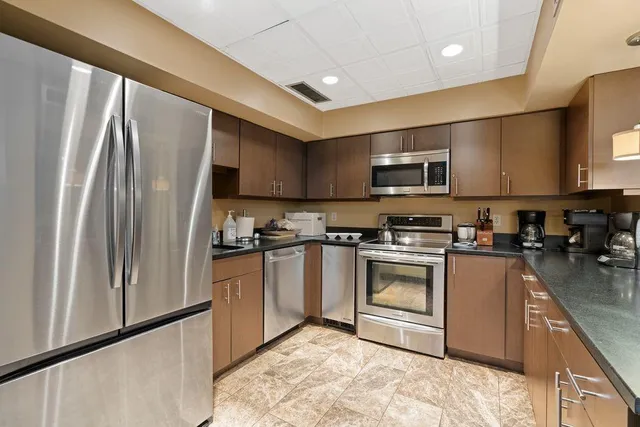 a kitchen with stainless steel appliances granite countertop a refrigerator stove a sink and a microwave