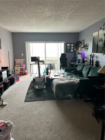 a living room with furniture fireplace and a large window