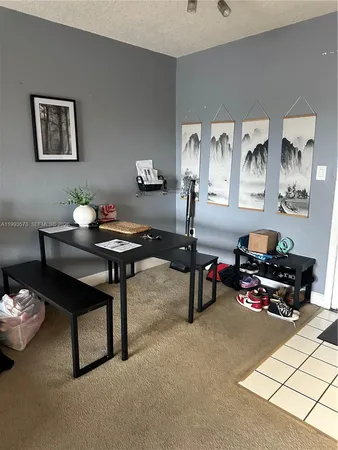 a living room with furniture and paintings on the wall