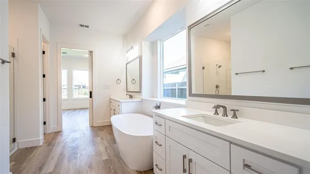 a bathroom with a sink a toilet a large mirror and shower