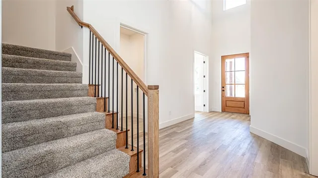 a view of a hallway with wooden floor and entryway