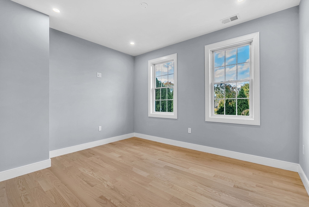 282 Nevada Street, Unit 282 Newton, MA 02460 - Photo 17 of 30 a view of an empty room with wooden floor and windows