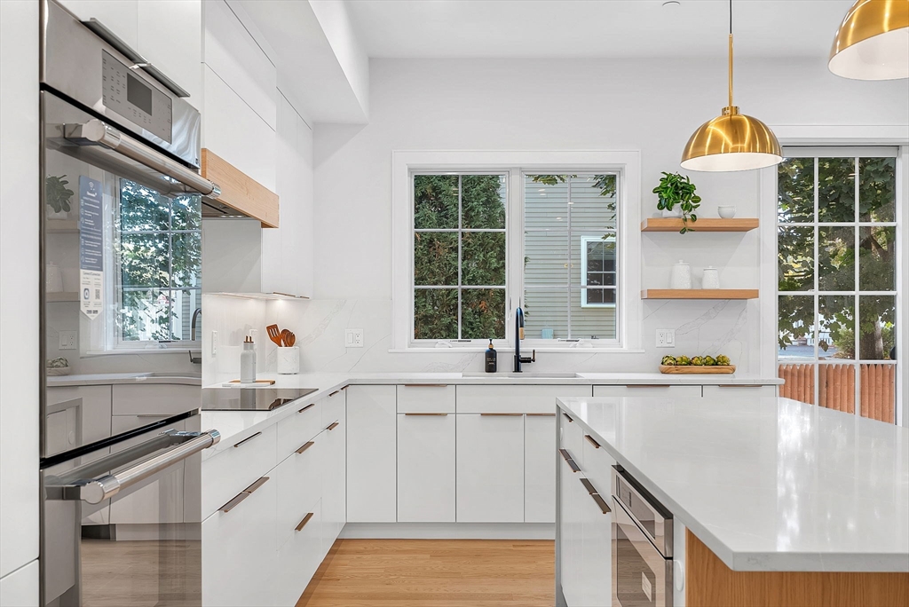 282 Nevada Street, Unit 282 Newton, MA 02460 - Photo 9 of 30 a kitchen with stainless steel appliances a sink a stove and a window