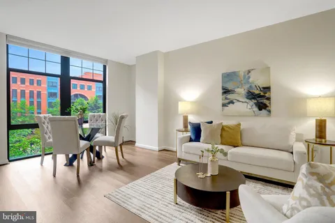 a living room with furniture wooden floor and a table