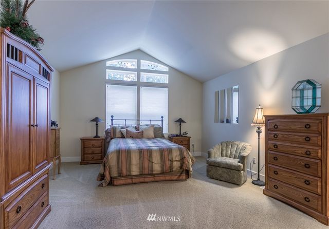 a spacious bedroom with a bed and a dresser