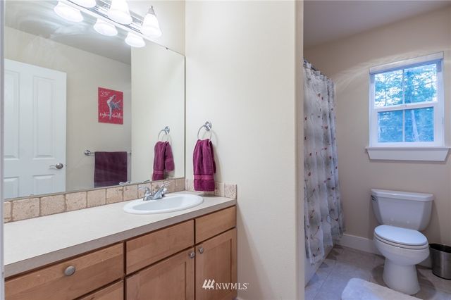 a bathroom with a sink vanity mirror and toilet