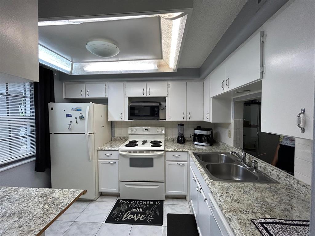 Undisclosed Address New Port Richey, FL 34652 - Photo 6 of 25 a kitchen with a sink a refrigerator and cabinets