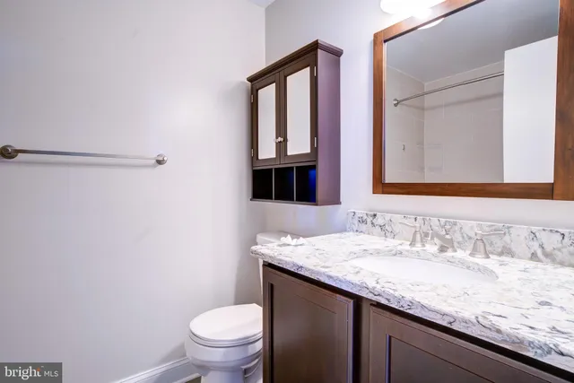 a white bath tub sitting next to a white sink and vanity