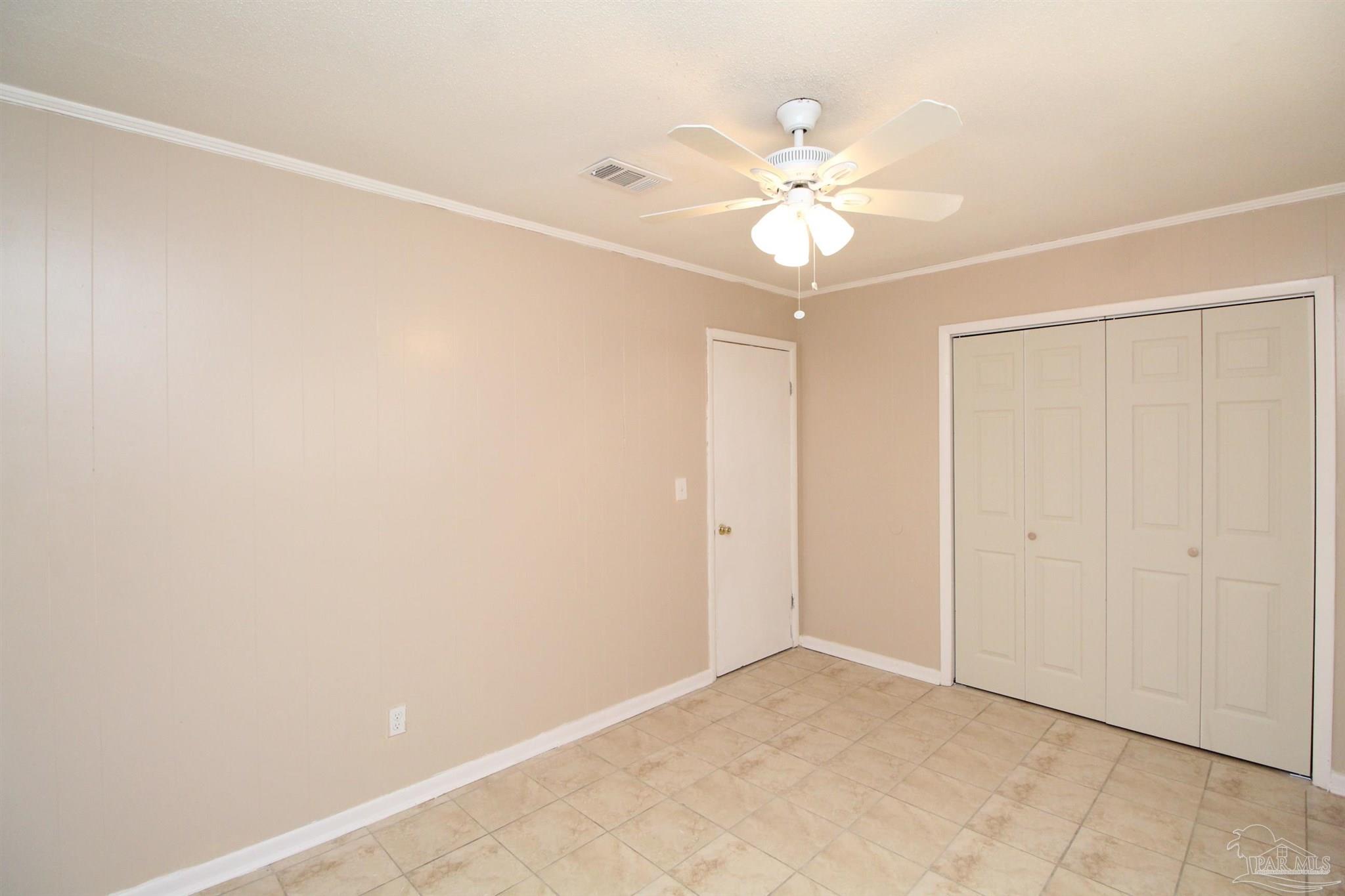 6620 Applegate Street Milton, FL 32570 - Photo 9 of 12 an empty room with closet and a chandelier fan