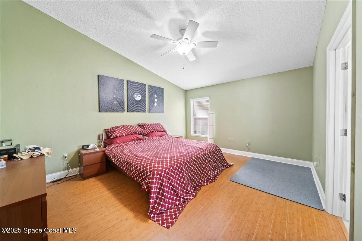 1366 Blazen Ridge Court Melbourne, FL 32934 - Photo 11 of 23 a bedroom with a bed and a chandelier
