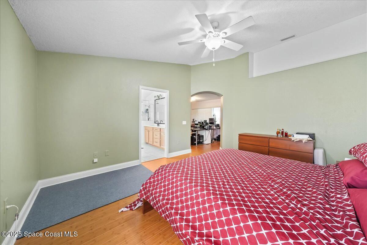 1366 Blazen Ridge Court Melbourne, FL 32934 - Photo 13 of 23 a bedroom with a bed and a chandelier
