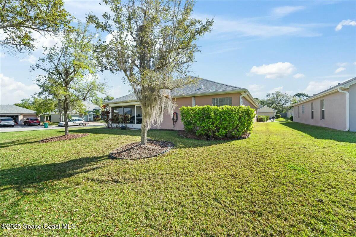 1366 Blazen Ridge Court Melbourne, FL 32934 - Photo 23 of 23 a view of a house with a large tree and plants