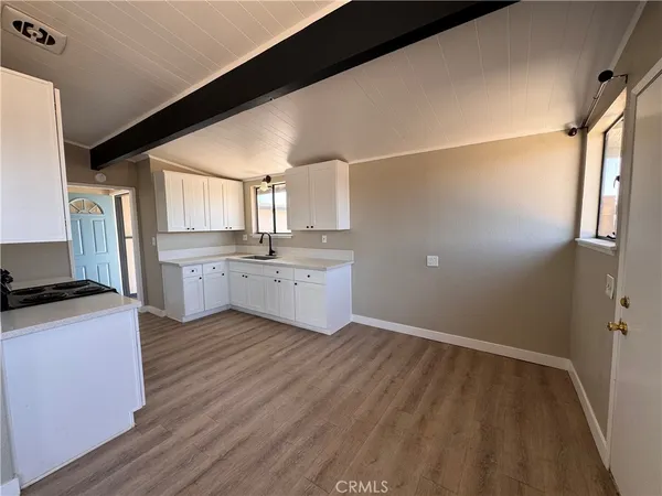 a view of a kitchen with wooden floor and electronic appliances