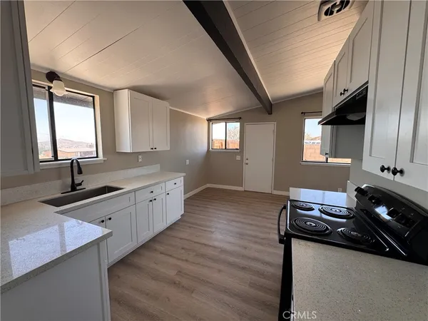 a kitchen with stainless steel appliances granite countertop a sink stove and cabinets