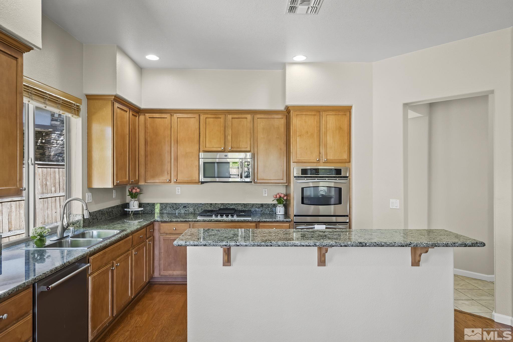 2685 Alder Bridge Court Reno, NV 89521 - Photo 11 of 38 a kitchen with stainless steel appliances granite countertop a sink a stove and cabinets