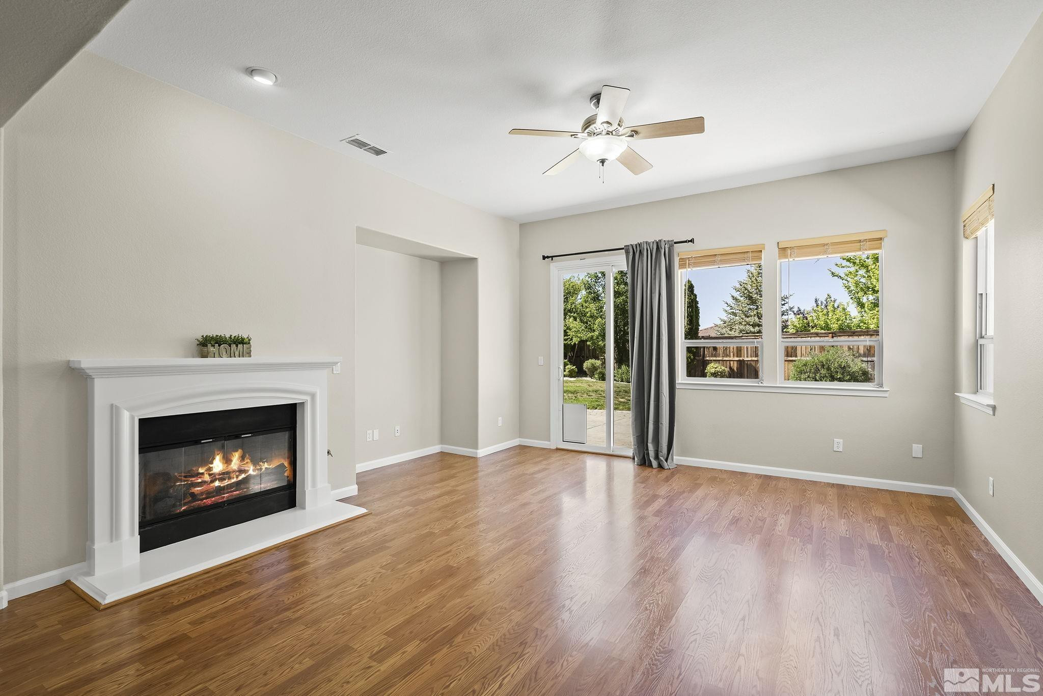 2685 Alder Bridge Court Reno, NV 89521 - Photo 7 of 38 a view of an empty room with wooden floor fireplace and a window