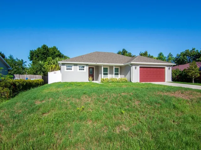 a front view of a house with a garden