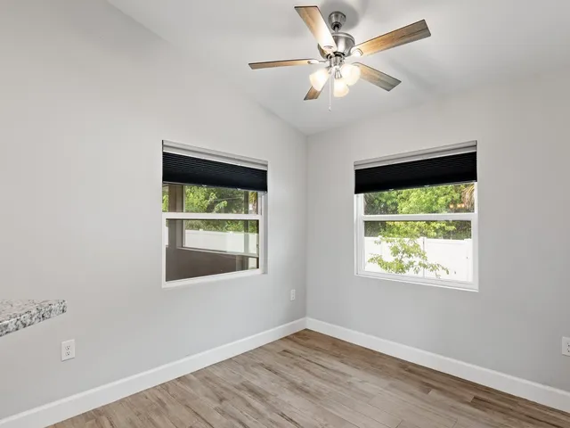 an empty room with a window and a ceiling fan