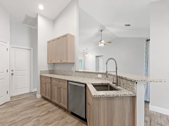 a kitchen with a sink a counter space and cabinets