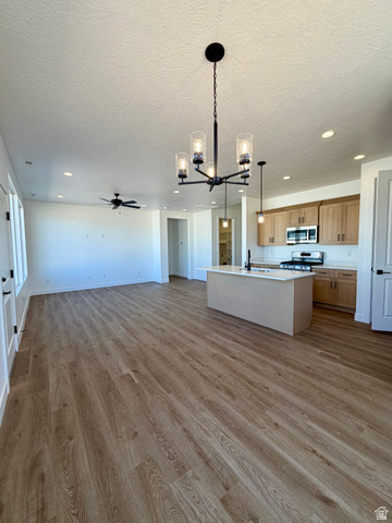 4956 North 925 East, Unit 87 Enoch, UT 84721 - Photo 5 of 19 Spacious open-concept living area featuring wood-finish flooring, recessed lighting, and a contemporary chandelier