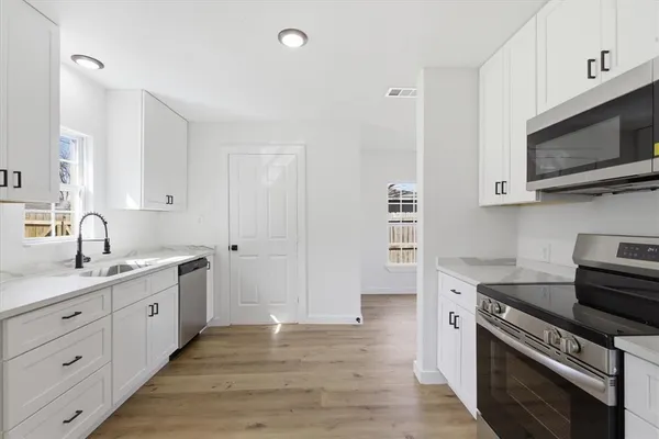 a kitchen with stainless steel appliances a stove microwave and cabinets
