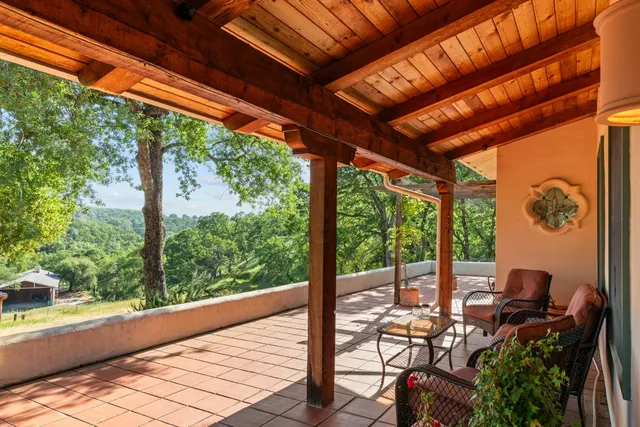 a view of a patio with table and chairs with wooden floor and fence
