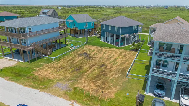 an aerial view of residential houses with outdoor space and ocean view