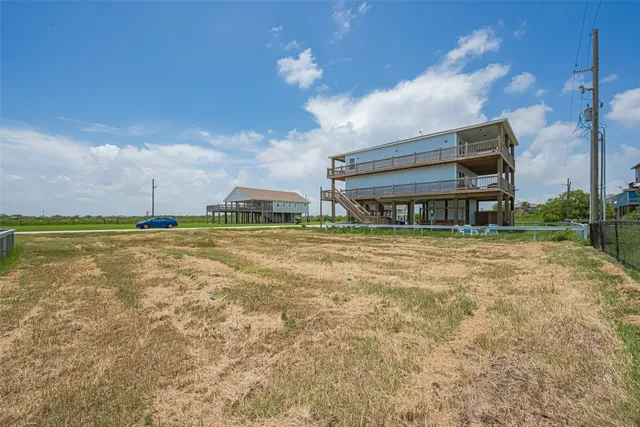 a view of a big house with a big yard and large trees