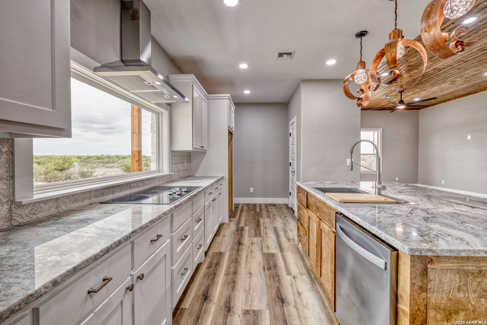 22 Greystone Hills Uvalde, TX 78801 - Photo 48 of 68 a kitchen with stainless steel appliances granite countertop a sink a stove and a wooden floors