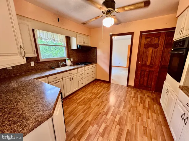 a kitchen with stainless steel appliances granite countertop a sink a stove and a microwave oven