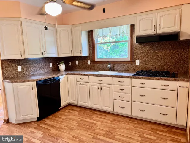 a kitchen with granite countertop a sink cabinets and a window