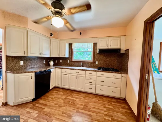 a kitchen with granite countertop a sink a stove and a microwave