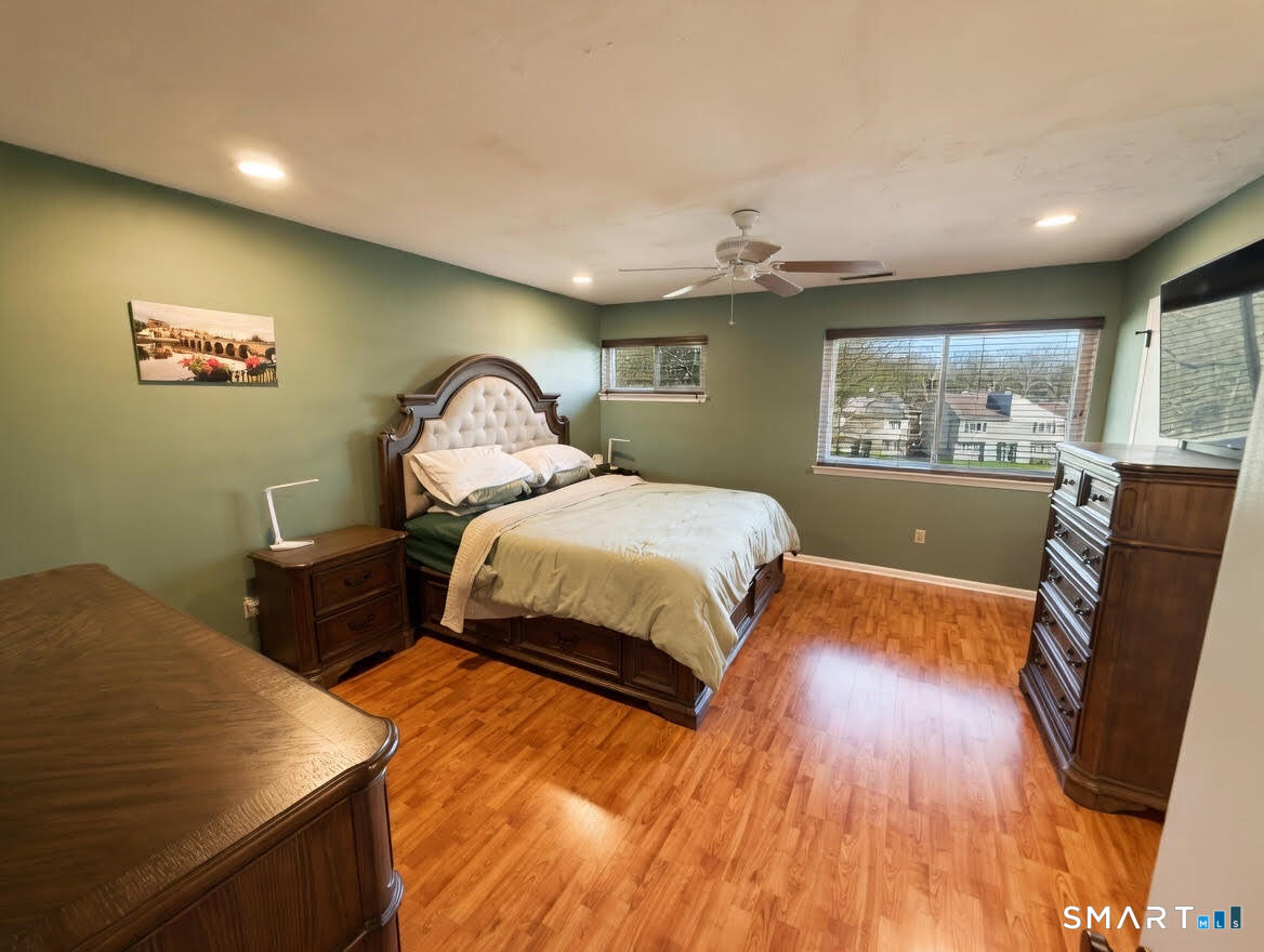 14 Sunrise Hill Road, Unit 14 Norwalk, CT 06851 - Photo 15 of 23 a bedroom with a bed and dresser with wooden floor