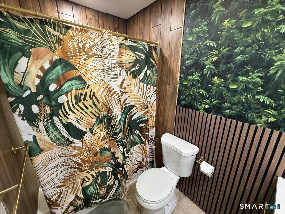 14 Sunrise Hill Road, Unit 14 Norwalk, CT 06851 - Photo 18 of 23 a white toilet sitting next to a shower curtain