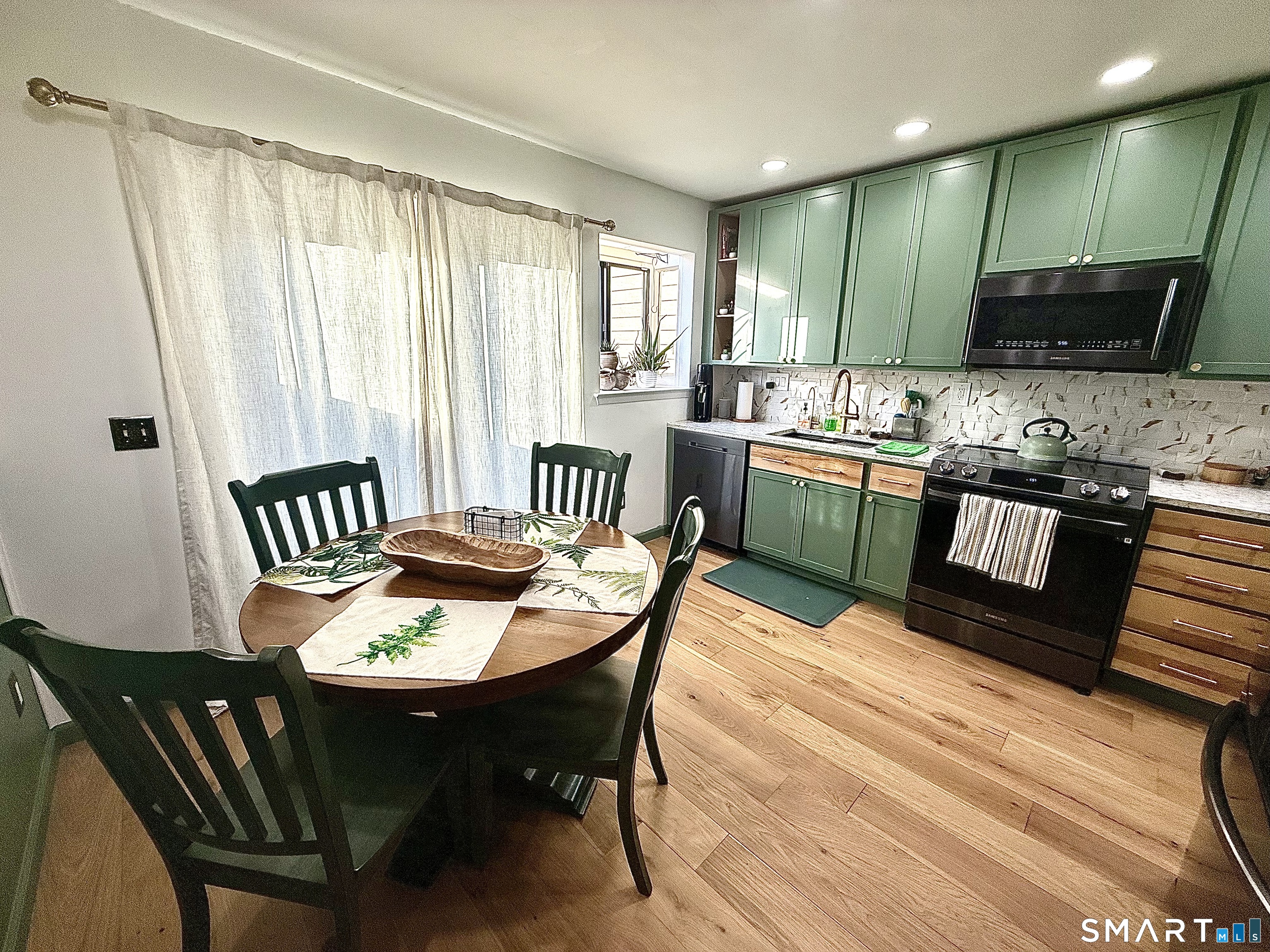 14 Sunrise Hill Road, Unit 14 Norwalk, CT 06851 - Photo 9 of 23 a kitchen with a dining table chairs and a wooden floor