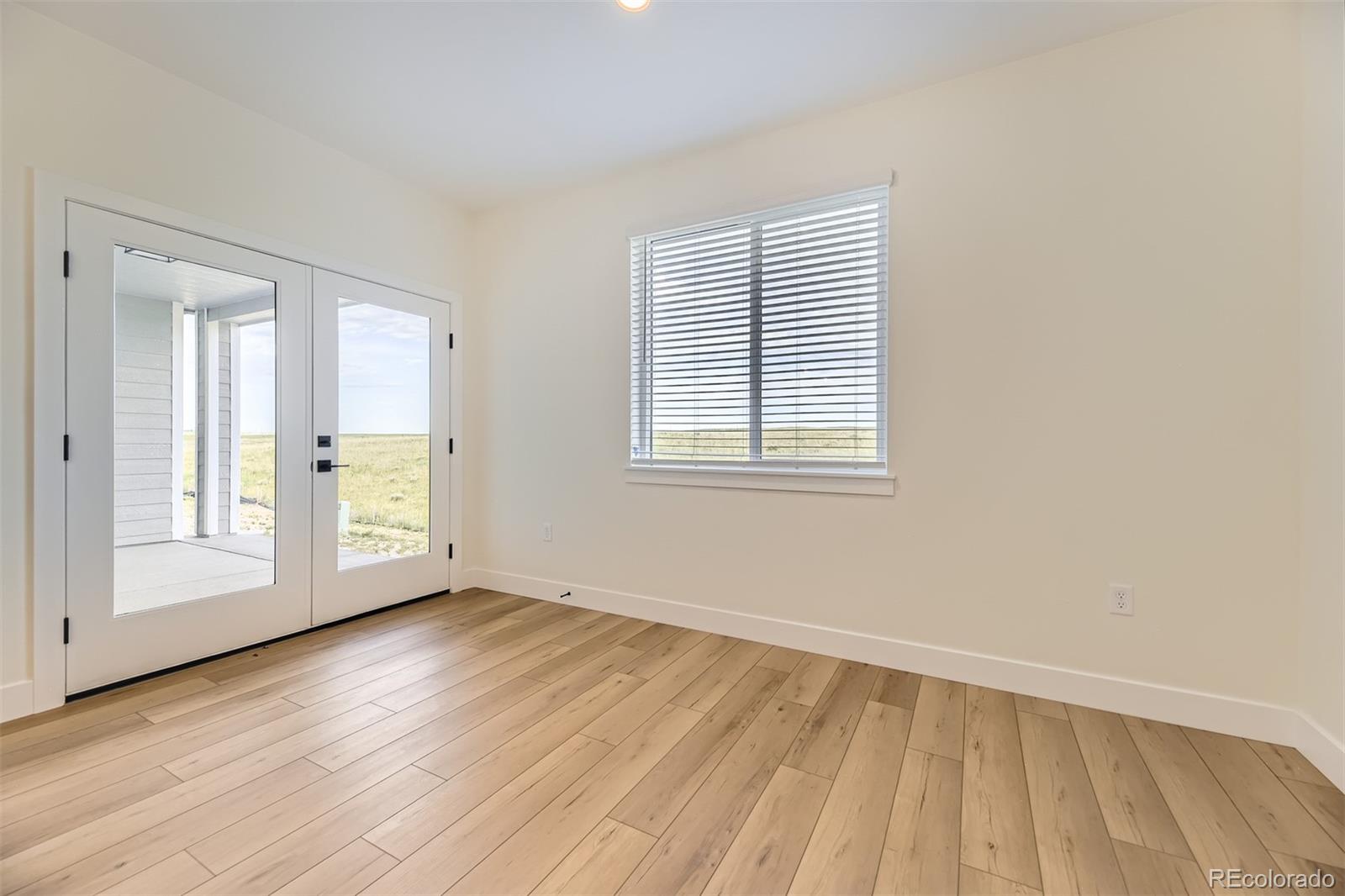 42979 Colonial Trail Elizabeth, CO 80107 - Photo 12 of 32 an empty room with wooden floor and windows
