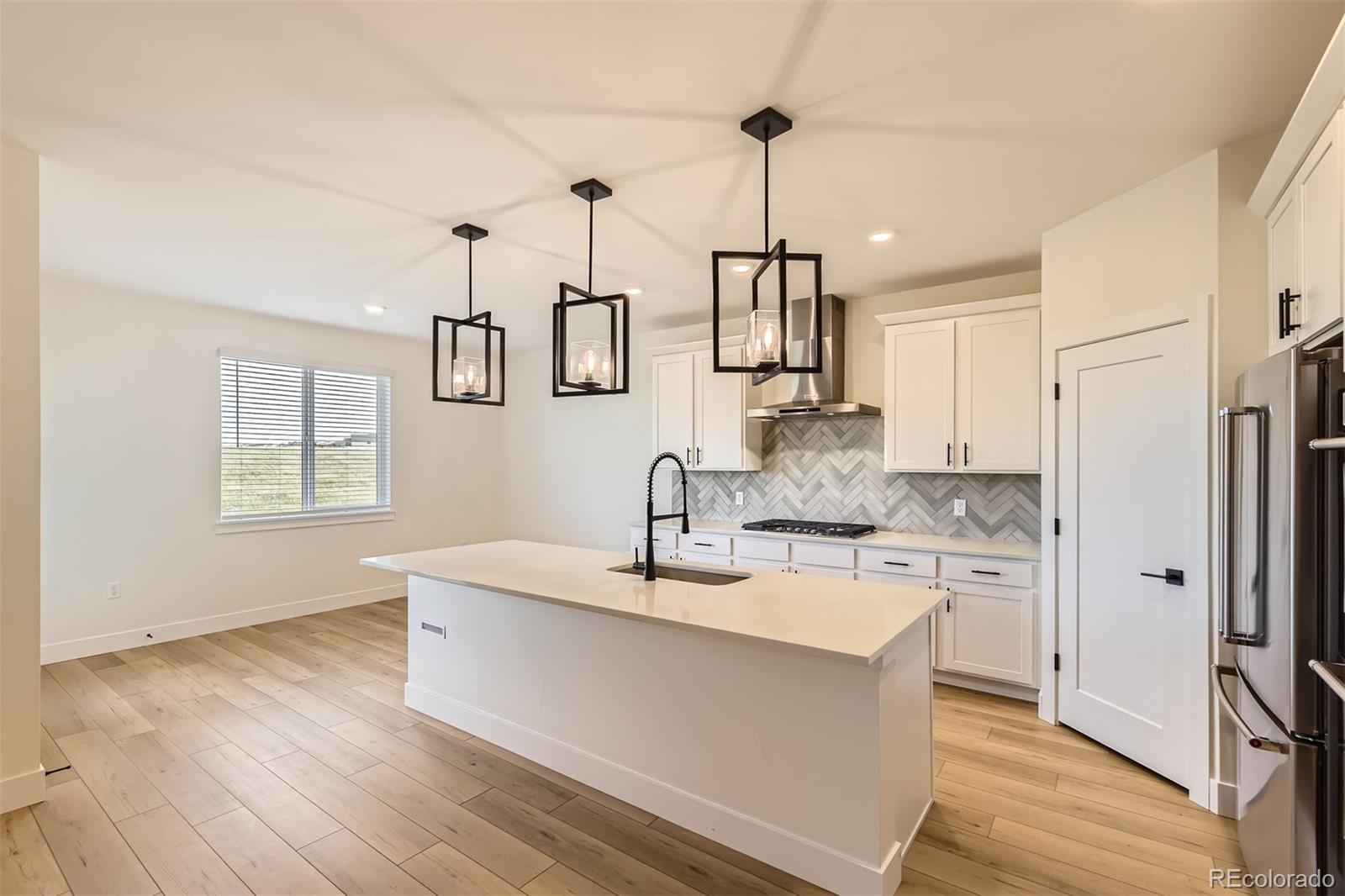 42979 Colonial Trail Elizabeth, CO 80107 - Photo 7 of 32 a large kitchen with kitchen island a large counter space a sink appliances and cabinets