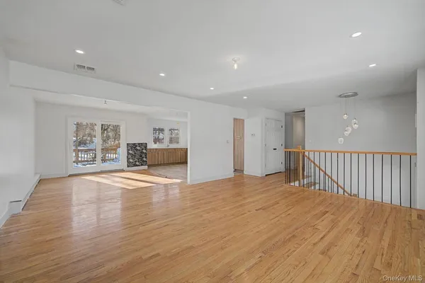 a big room with wooden floor and bathroom view