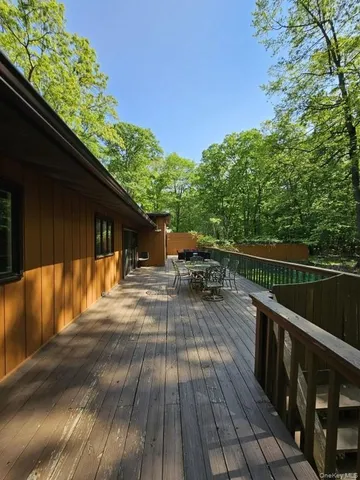 a balcony with wooden floor and outdoor seating