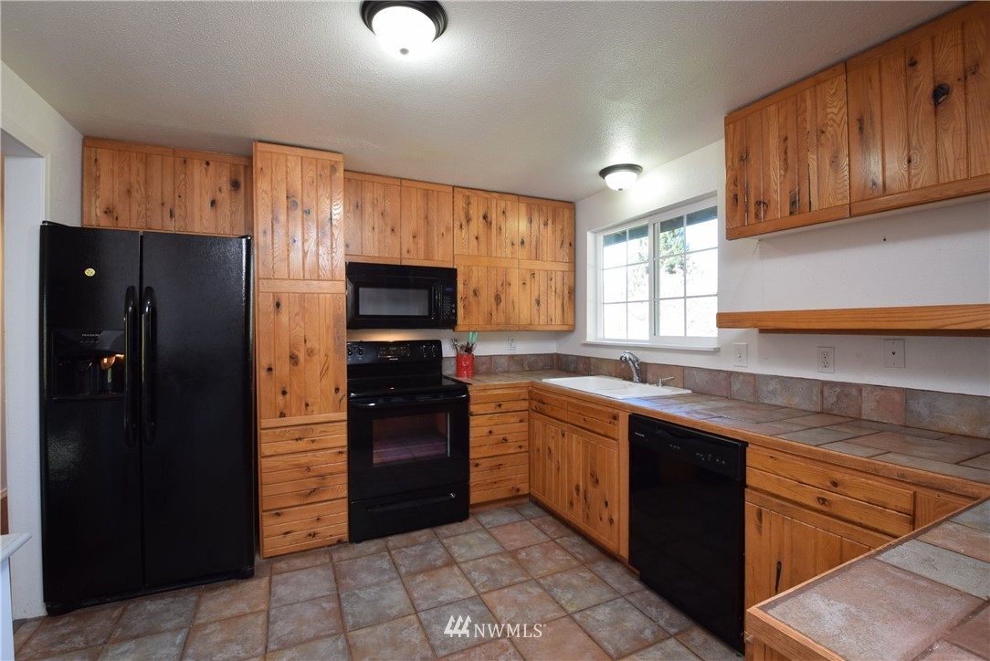 2631 166th Street Southeast Bothell, WA 98012 - Photo 4 of 18 a kitchen with stainless steel appliances granite countertop a refrigerator and a sink
