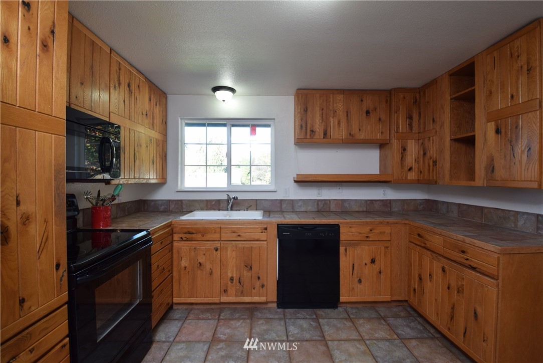 2631 166th Street Southeast Bothell, WA 98012 - Photo 5 of 18 a kitchen with a sink stove and cabinets