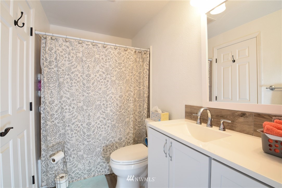 2631 166th Street Southeast Bothell, WA 98012 - Photo 7 of 18 a bathroom with a granite countertop sink toilet and a shower